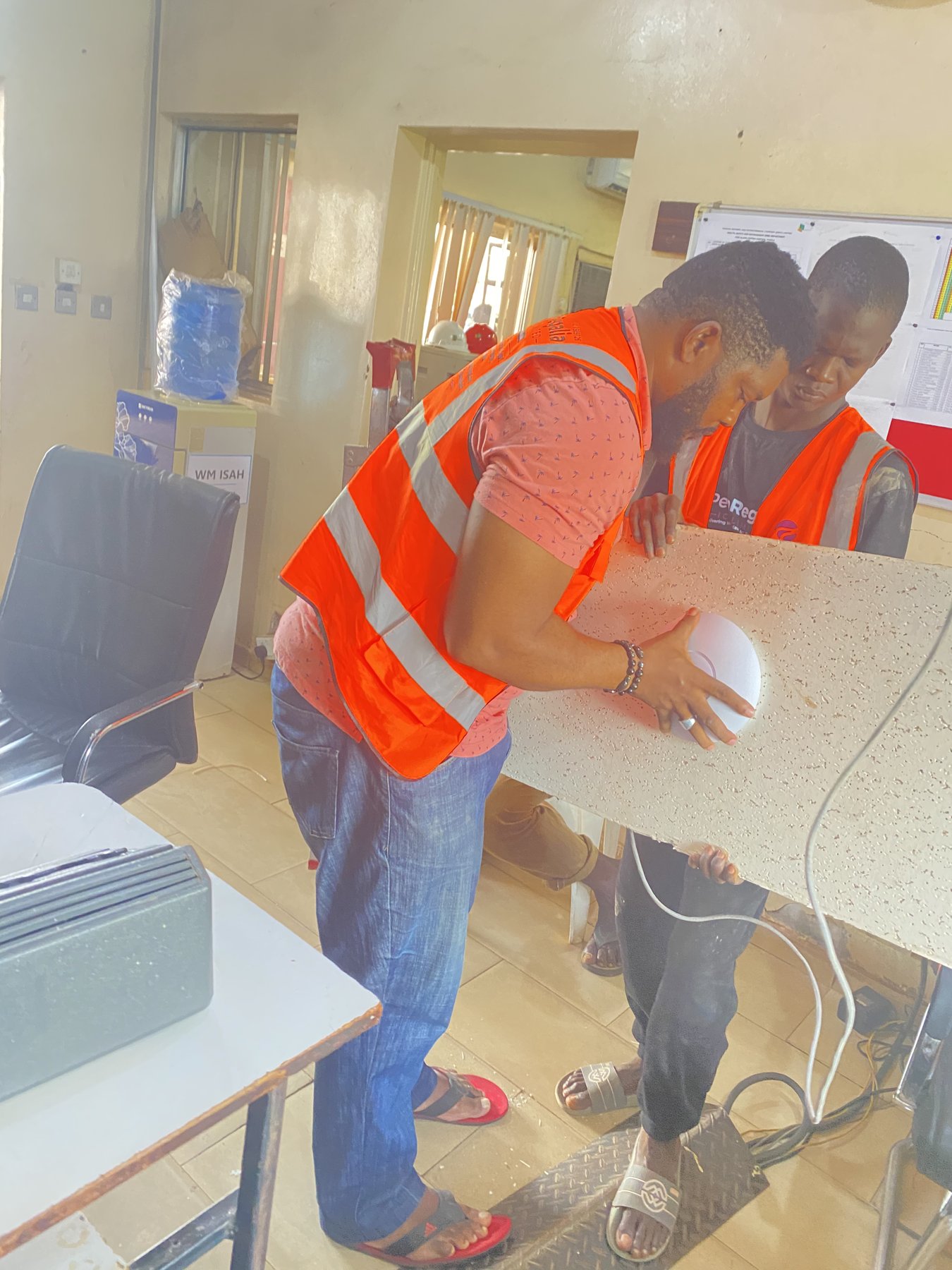Technicians working together on the access point mounting.